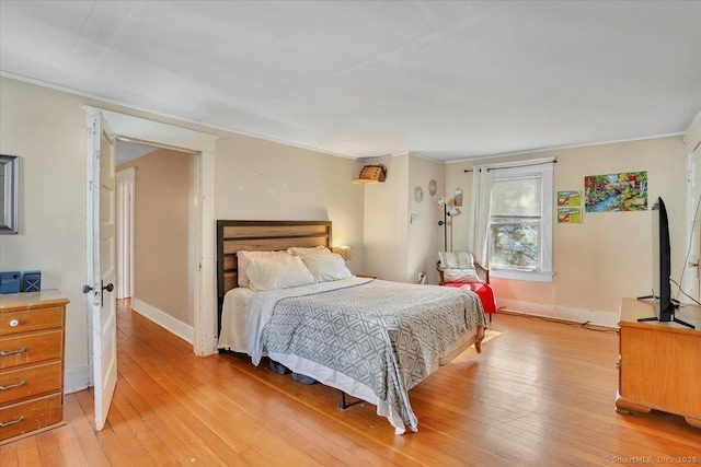 bedroom featuring crown molding, baseboards, and light wood-type flooring