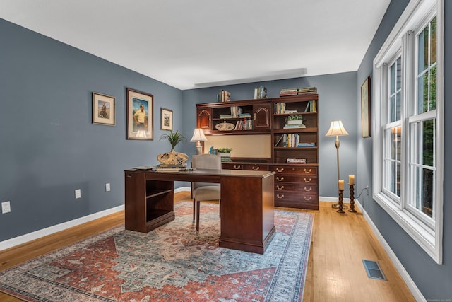 office featuring visible vents, light wood-type flooring, and baseboards