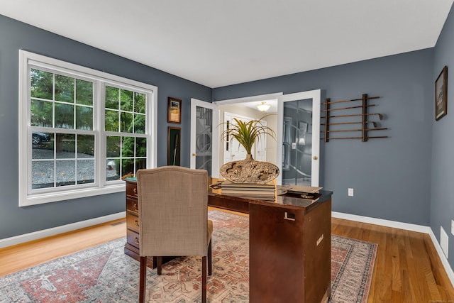 office space with baseboards and wood finished floors