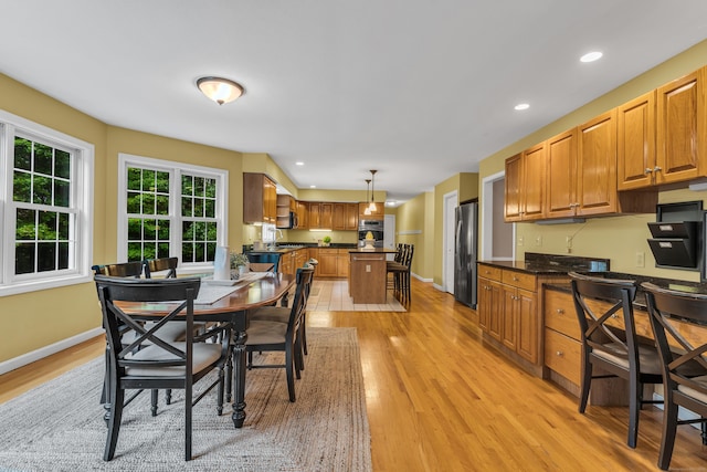 dining room with recessed lighting, baseboards, and light wood-style floors