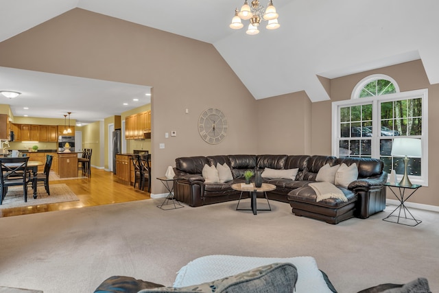 living room with high vaulted ceiling, a notable chandelier, baseboards, and light carpet