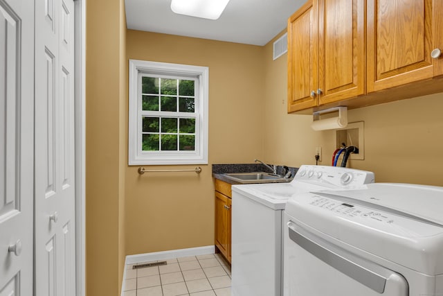 washroom featuring visible vents, independent washer and dryer, a sink, cabinet space, and light tile patterned floors