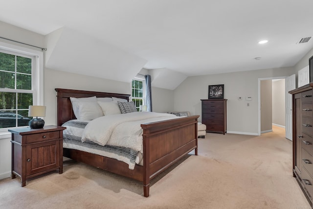 bedroom with visible vents, light carpet, baseboards, and vaulted ceiling