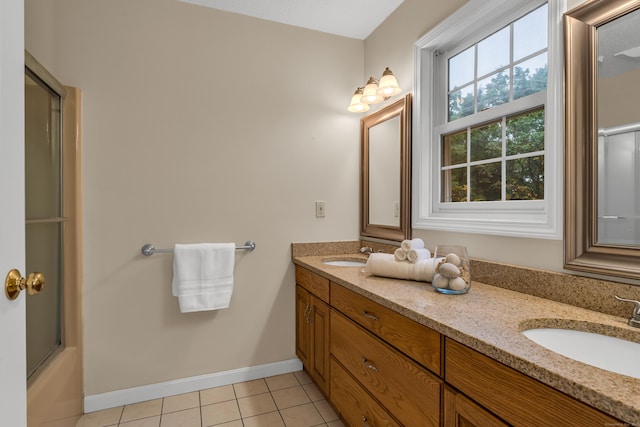 bathroom with a sink, baseboards, double vanity, and tile patterned flooring