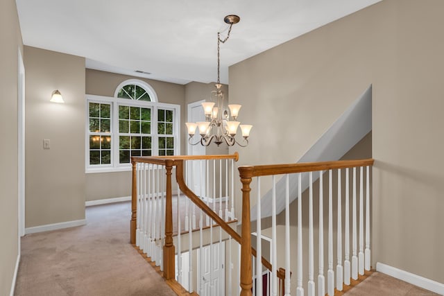 stairs with visible vents, baseboards, a notable chandelier, and carpet