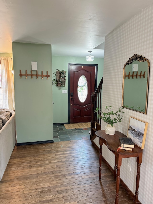 entryway with stairway, wood-type flooring, and wallpapered walls