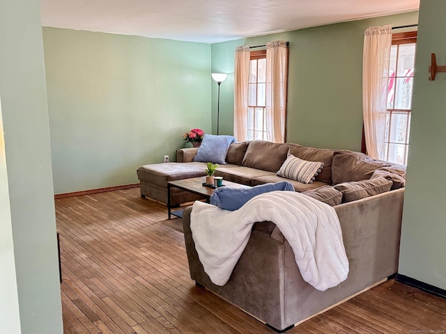 living area featuring a healthy amount of sunlight, dark wood-style floors, and baseboards