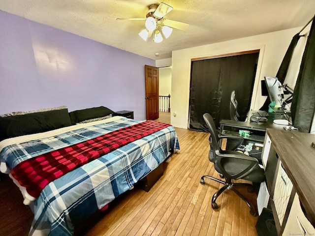 bedroom featuring ceiling fan, a textured ceiling, and light wood-style flooring