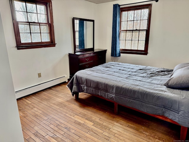 bedroom featuring a baseboard radiator and hardwood / wood-style floors