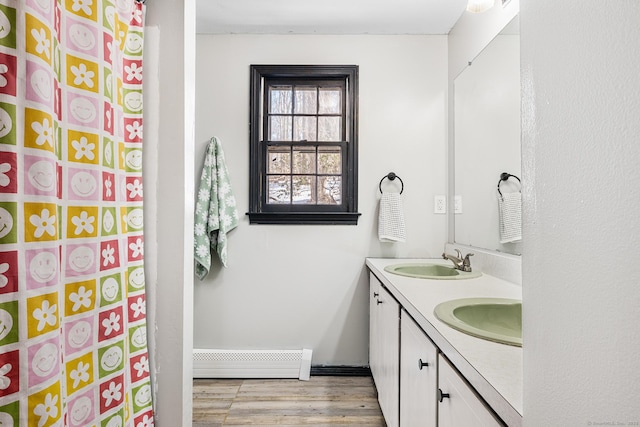 bathroom with double vanity, wood finished floors, a sink, and curtained shower