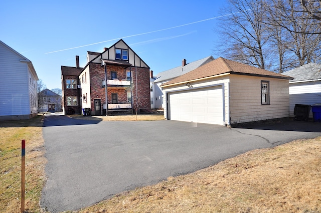 view of front of home with a garage and an outbuilding