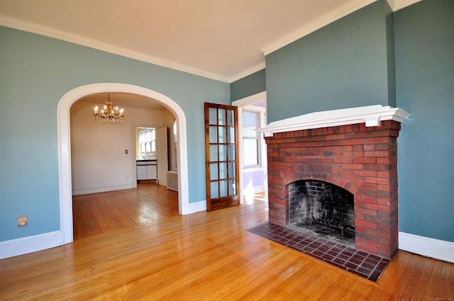 unfurnished living room with ornamental molding, a fireplace, baseboards, and hardwood / wood-style flooring