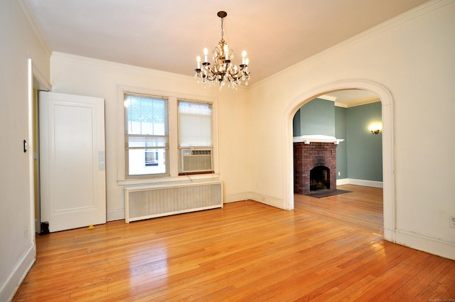 unfurnished living room with light wood-style flooring, a fireplace, radiator heating unit, and ornamental molding