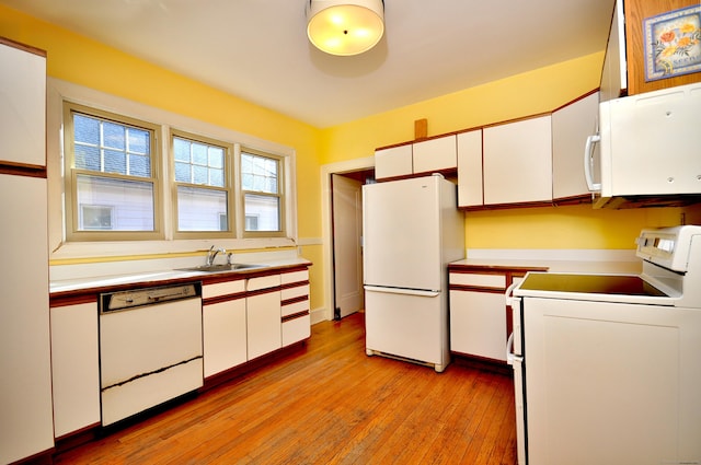 kitchen featuring white appliances, white cabinets, light countertops, and light wood-type flooring