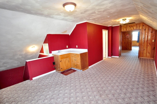 bonus room featuring wood walls, lofted ceiling, and carpet floors