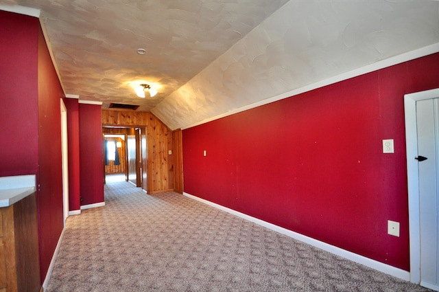 corridor with vaulted ceiling, carpet, baseboards, and visible vents