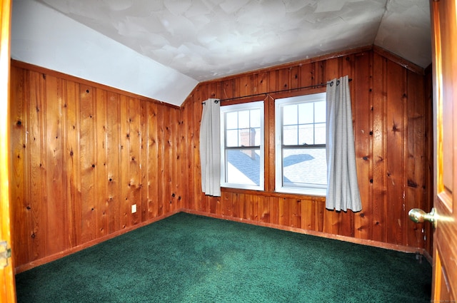 bonus room featuring wood walls, baseboards, lofted ceiling, and carpet floors