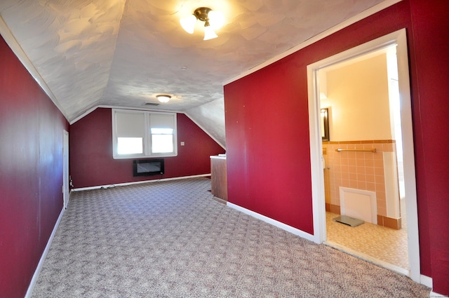 additional living space featuring lofted ceiling, carpet flooring, and visible vents