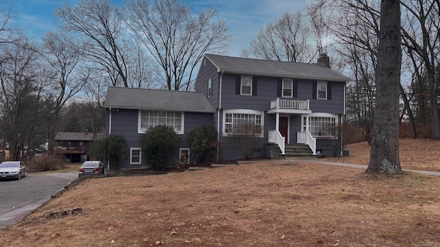 view of front of property featuring a balcony and a chimney