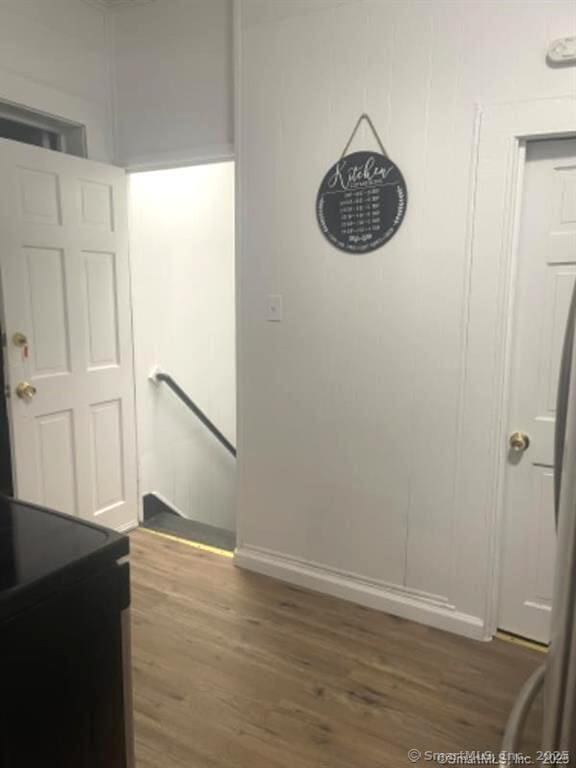 hallway featuring wood finished floors and an upstairs landing