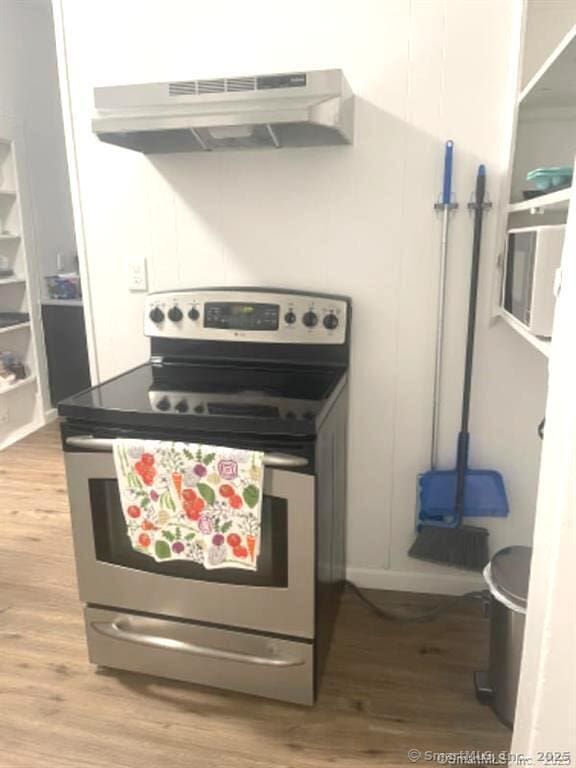 kitchen featuring light wood-style flooring, under cabinet range hood, and stainless steel range with electric cooktop