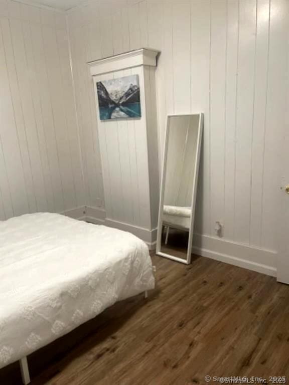 bedroom with baseboards and dark wood finished floors