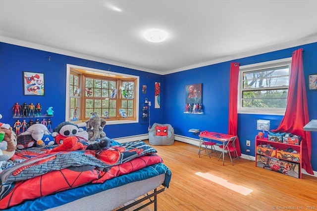 bedroom with wood finished floors, baseboards, and baseboard heating