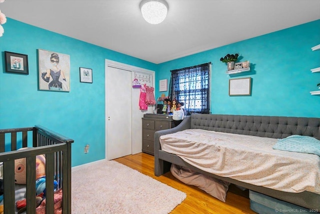 bedroom featuring wood finished floors, a closet, and baseboards