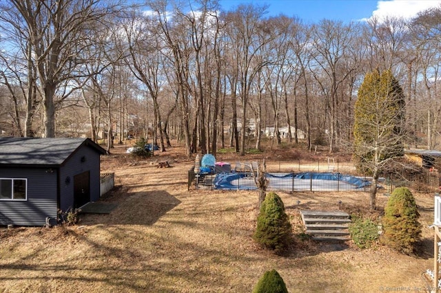 view of yard with a fenced in pool and an outbuilding