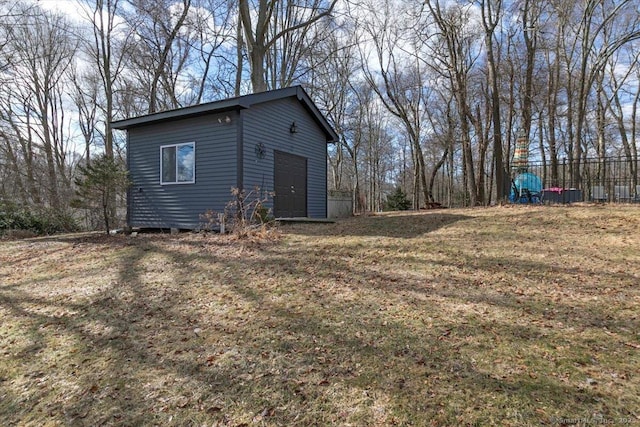 exterior space featuring an outbuilding, a lawn, and fence