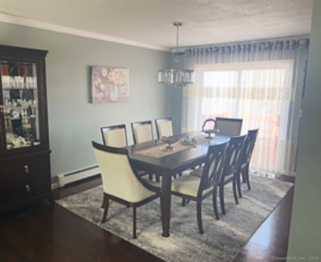 dining room featuring a notable chandelier, crown molding, a baseboard heating unit, and dark wood-type flooring