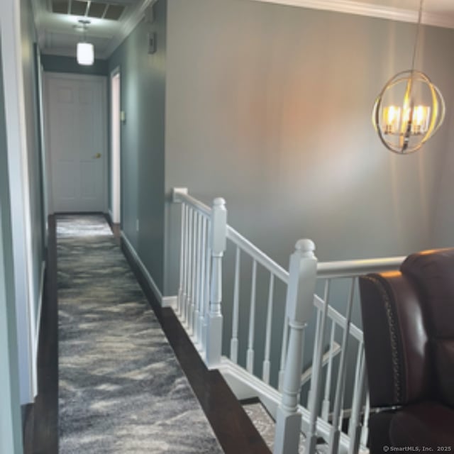 hallway featuring visible vents, baseboards, an upstairs landing, and crown molding