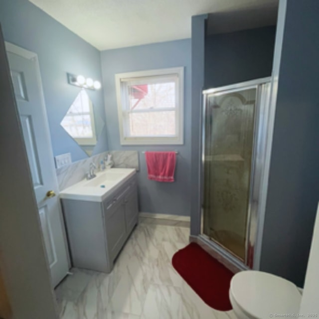 bathroom featuring a shower stall, baseboards, toilet, marble finish floor, and vanity