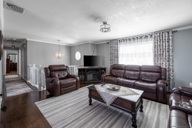 living area with a notable chandelier, visible vents, a textured ceiling, and hardwood / wood-style floors