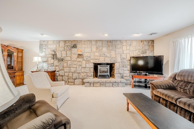 carpeted living area featuring visible vents and a wood stove