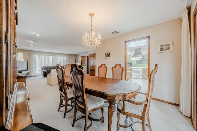 dining room with a notable chandelier, visible vents, light colored carpet, and baseboards