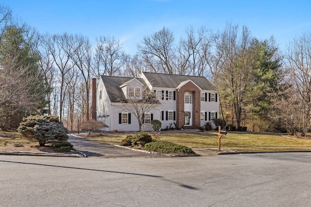 view of front of house featuring a front lawn and a chimney