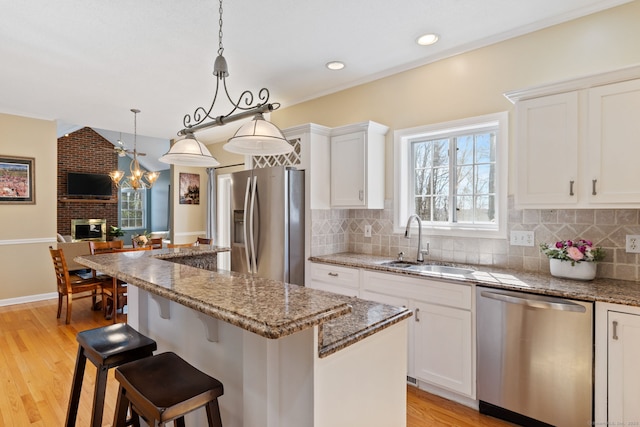 kitchen with a sink, backsplash, a kitchen island, and appliances with stainless steel finishes