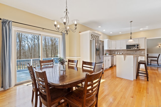 dining space with recessed lighting, a notable chandelier, and light wood-style flooring