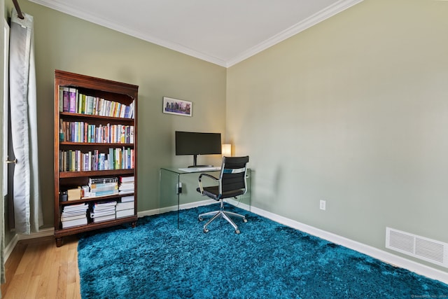 office with wood finished floors, baseboards, visible vents, and ornamental molding