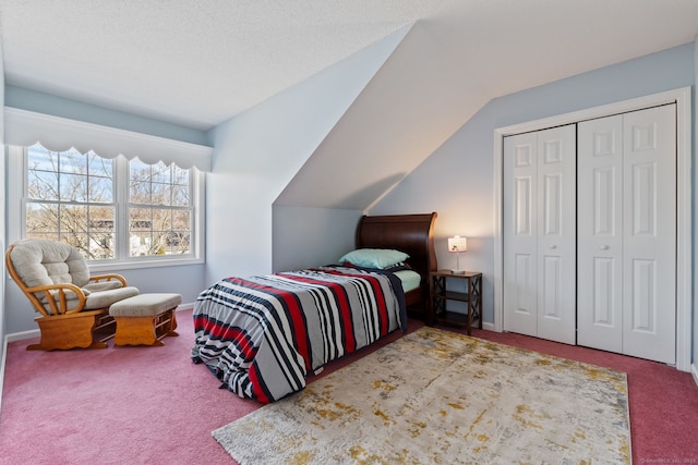 carpeted bedroom with a closet, baseboards, and vaulted ceiling