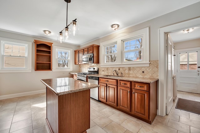 kitchen with a sink, decorative backsplash, appliances with stainless steel finishes, and a kitchen island