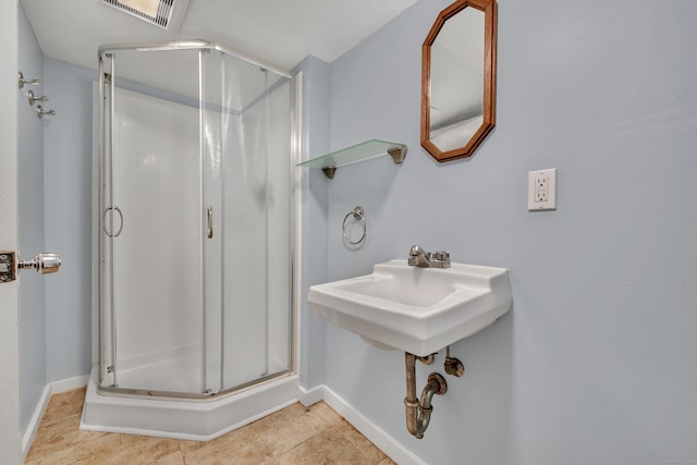 bathroom featuring tile patterned flooring, baseboards, visible vents, and a stall shower