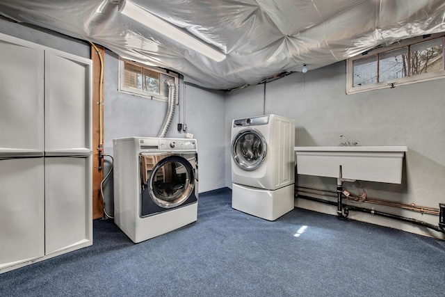 laundry area featuring a sink, carpet flooring, washing machine and dryer, and laundry area