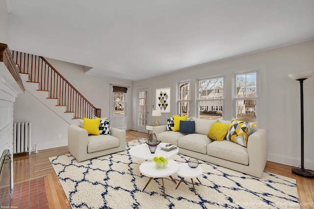 living room with stairway, radiator heating unit, wood finished floors, and baseboards