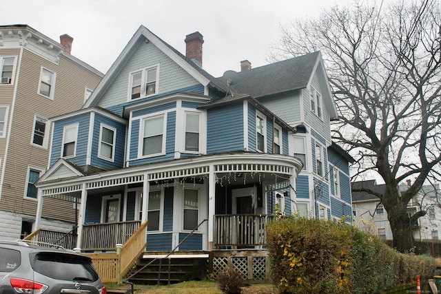 view of front facade featuring a porch and a chimney