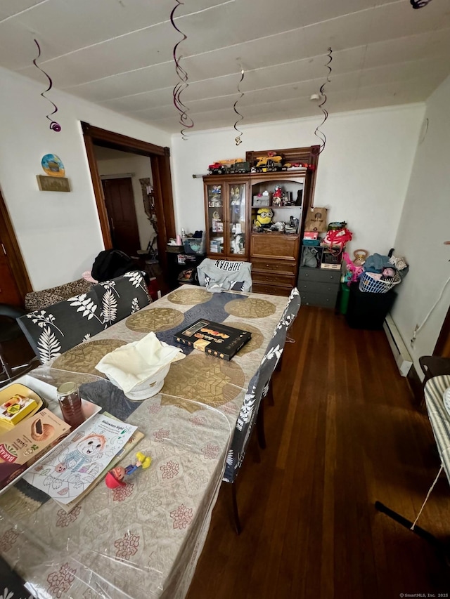 interior space featuring a baseboard heating unit and wood finished floors