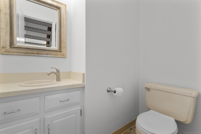 bathroom featuring baseboards, toilet, and vanity