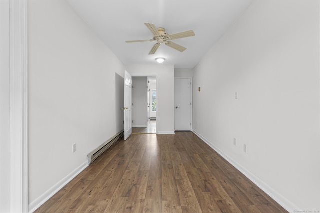 empty room featuring ceiling fan, wood finished floors, baseboards, and a baseboard radiator