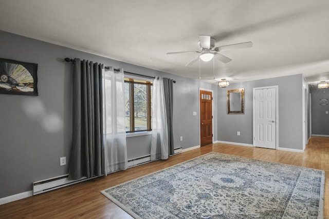 unfurnished room featuring a ceiling fan, wood finished floors, and baseboards